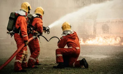 Firefighters using fire hose extinguishing burning fire