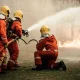 Firefighters using fire hose extinguishing burning fire